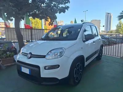 Fiat Panda bianca davanti alla ringhiera con le bandiere