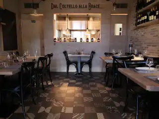 La sala con la cucina a vista e la scritta «Dal coltello alla brace»