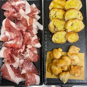 Prosciutto crudo con bruschette e frittelle, su due taglieri