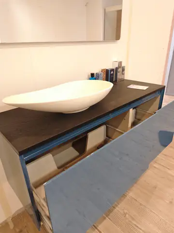 Mobile bagno con piano scuro e lavabo bianco da appoggio