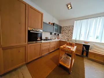 Cucina in legno di rovere con un carrello, sotto una finestra