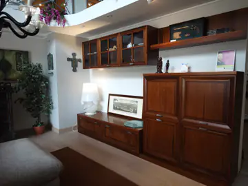 Soggiorno classico in legno scuro, con vetrine e credenza