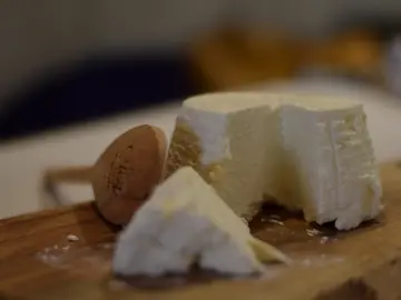 Una ricotta tagliata su un tagliere di legno