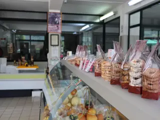 Ciambelle e biscotti confezionati sulla mensola sopra il banco