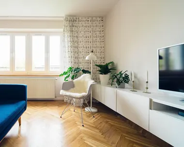 Soggiorno luminoso con parquet a spina di pesce e mobile basso bianco