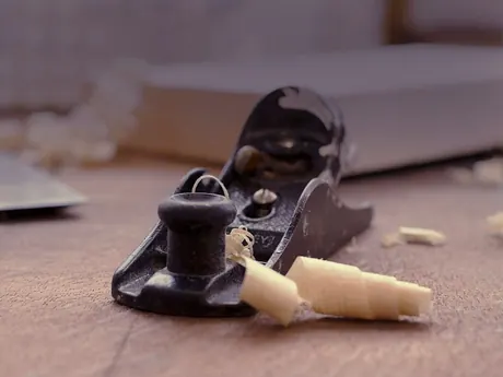 Una pialla a mano sul legno, con i riccioli dei trucioli