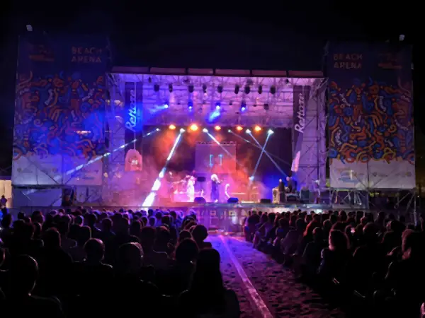 La Beach Arena di notte, con il palco illuminato di viola e il pubblico