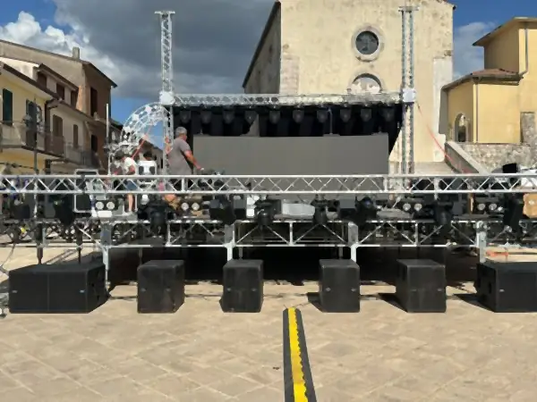 Palco montato in una piazza, con i tralicci, le casse e le luci