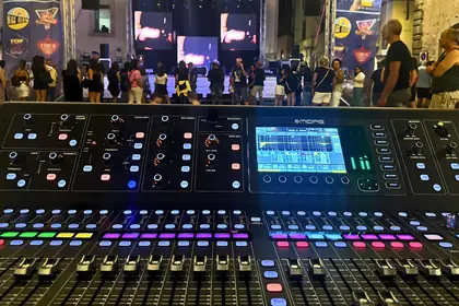 Il mixer digitale della regia audio, davanti a un palco in piazza