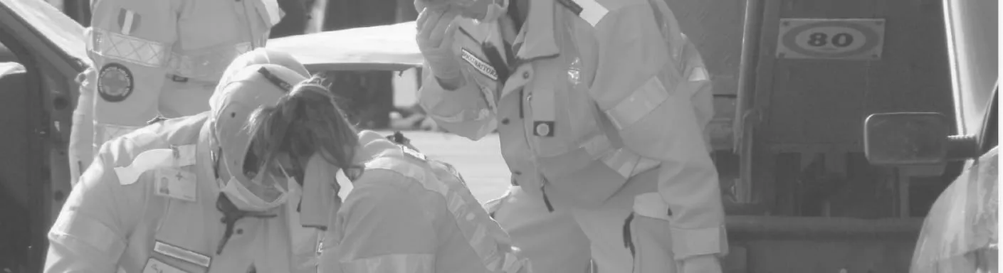 Soccorritori in divisa al lavoro accanto a un'auto incidentata, in bianco e nero