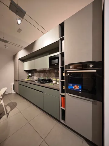 Cucina lineare grigio salvia con colonne grigie e forno a incasso
