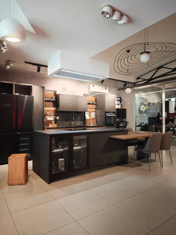 Lo showroom, con una cucina nera a isola al centro