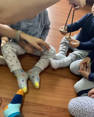 Bambini seduti in cerchio sul pavimento, con i calzini colorati