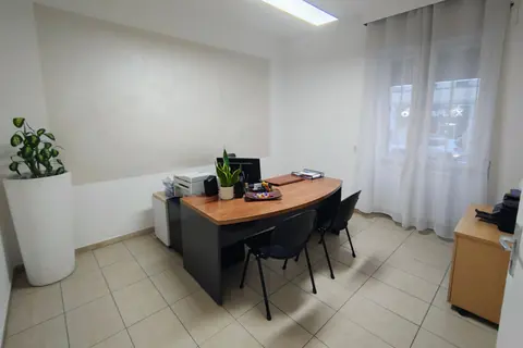 Un ufficio dell'agenzia, con la scrivania in legno e le piante