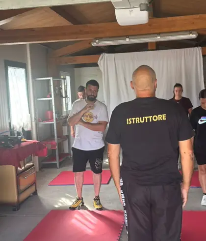 L'istruttore, con la maglia «Istruttore», davanti a un gruppo di allievi sui tappetini