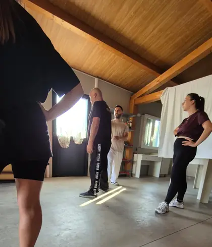 Allievi in piedi sul pavimento della sala, sotto il tetto in legno, durante un'esercitazione