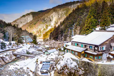 Una valle di montagna innevata, con le case tra i boschi
