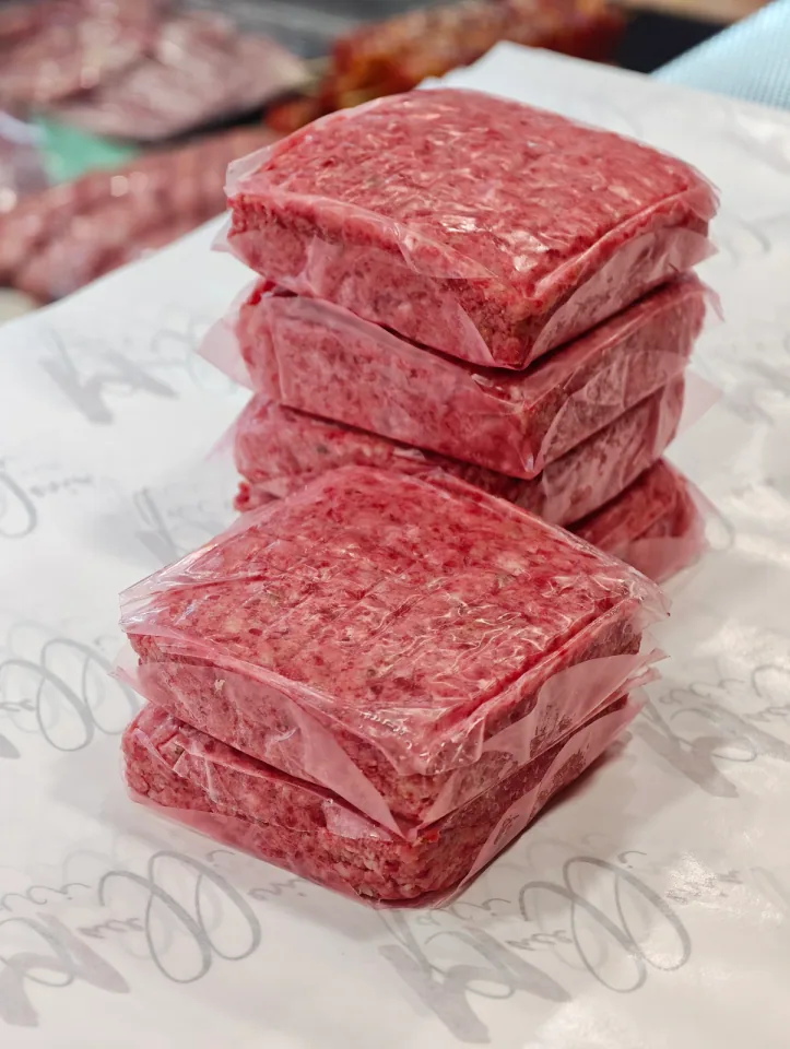Panetti di macinato sottovuoto con spiedini sfocati sullo sfondo