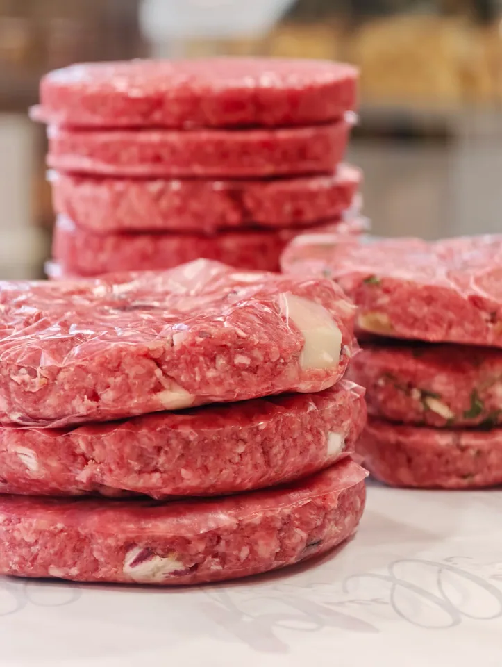 Tre pile di hamburger confezionati disposte sul bancone