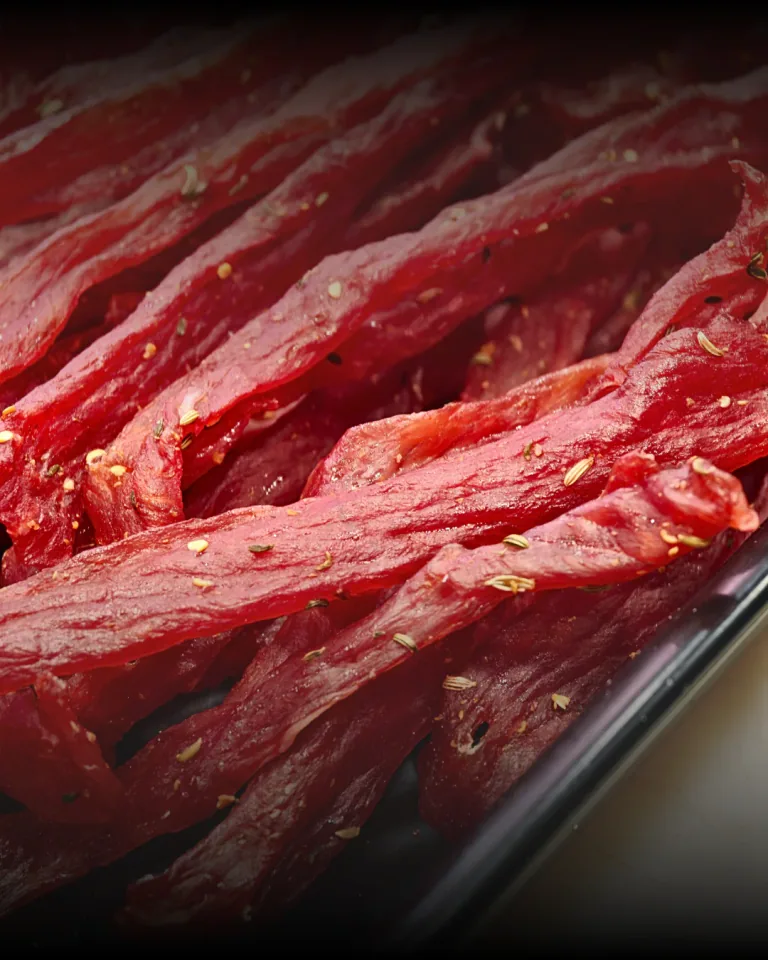 Striscioline di carne essiccata con semi di finocchio in un vassoio nero