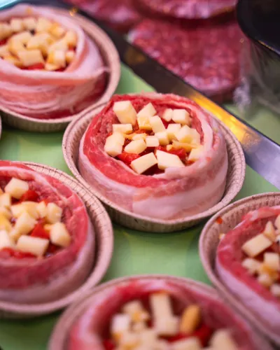Nel banco, tortini di carne avvolti nella pancetta con dadini di formaggio e peperone