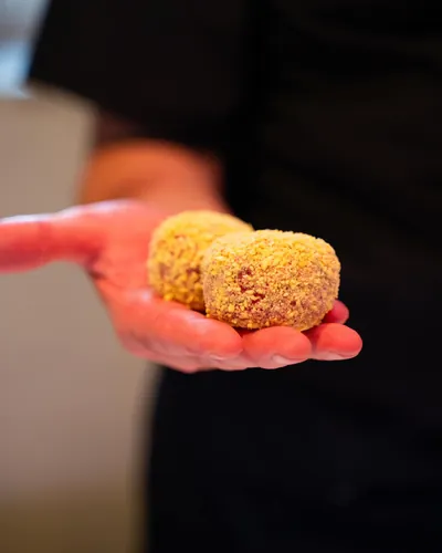 Due polpette impanate nel palmo di una mano