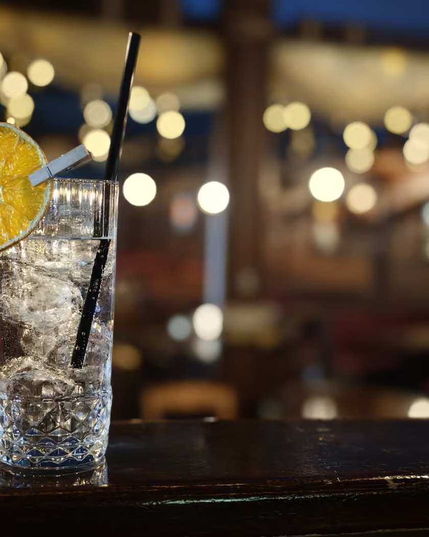 Cocktail con fetta di arancia sul bancone del May Flower