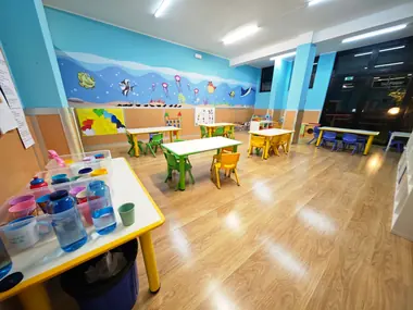 L'aula Nemo: tavoli bassi con le sedie gialle e verdi, il mare dipinto sulle pareti