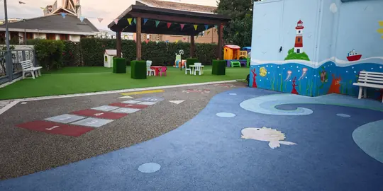 Il cortile dipinto come il mare, con il pergolato e i giochi sullo sfondo