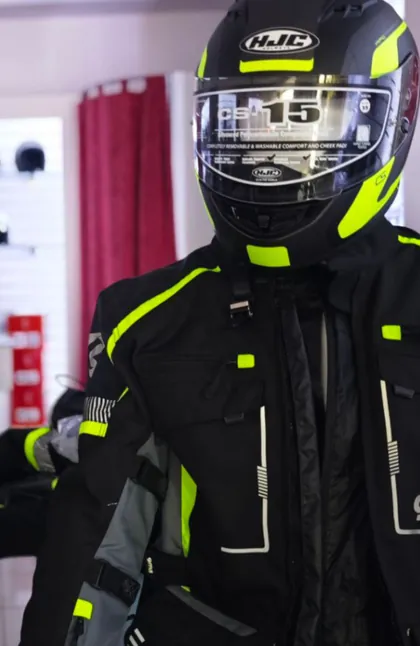 Un casco HJC nero e giallo fluo su una giacca da moto abbinata, nel negozio