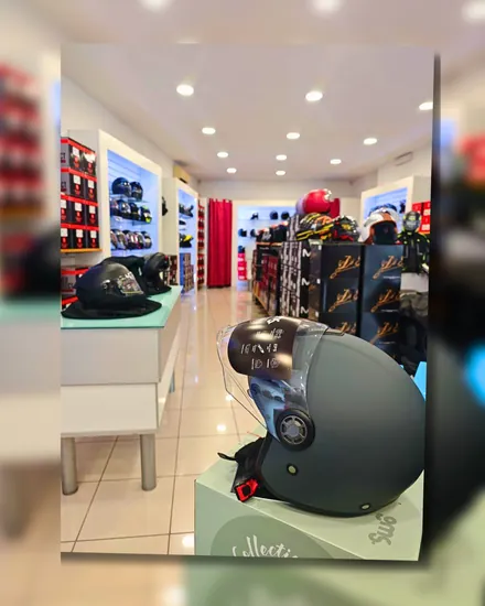 La sala del negozio, con le pareti di caschi esposti e un jet grigio in primo piano