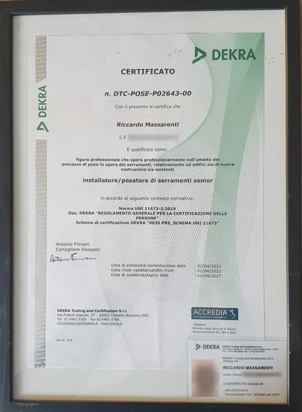 Il certificato DEKRA di Riccardo Massarenti come installatore e posatore di serramenti senior, secondo la norma UNI 11673-2:2019, incorniciato, con il codice fiscale e la fototessera sfocati