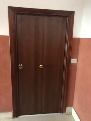 Porta blindata in legno scuro sul pianerottolo