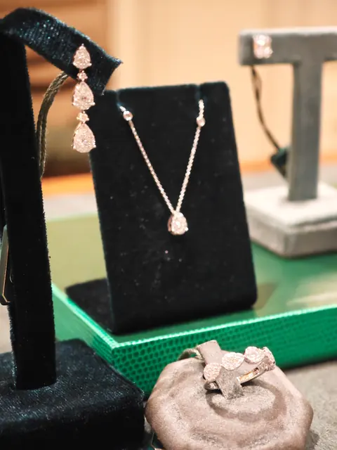 Orecchini pendenti e collana con punto luce a goccia, esposti in vetrina