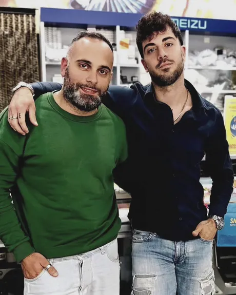 I due titolari di Smartphone Store MD, abbracciati davanti agli scaffali del negozio