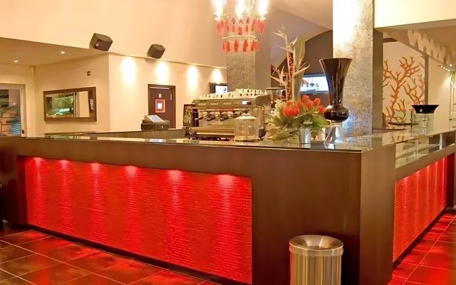 Il bancone di un bar con il fronte rosso illuminato, allestito da Spaziani Arreda