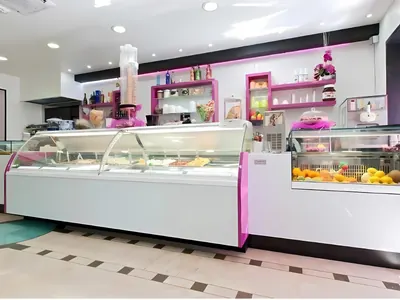 Gelateria con le vetrine refrigerate curve e i ripiani fucsia: un lavoro di Spaziani Arreda