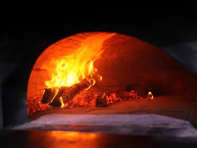 Un forno a legna in mattoni, con la fiamma accesa