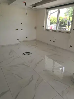 Stanza con il pavimento appena posato in grandi lastre effetto marmo