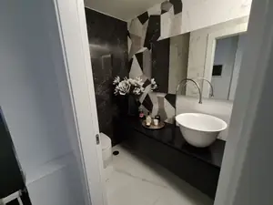 Bagno con rivestimento in lastre bianche e nere e lavabo da appoggio