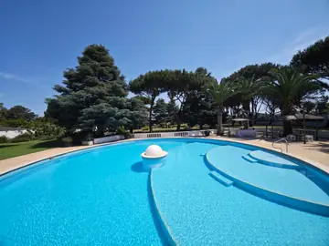 La piscina e il giardino con i pini, in una giornata di sole